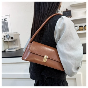 Close-up of a brown retro baguette bag featuring a gold buckle and premium PU leather