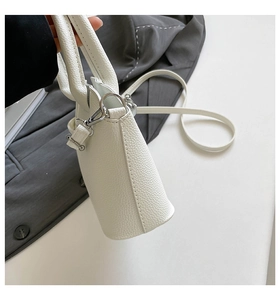 Detailansicht der weißen Handtasche aus Litschi-Leder mit silbernen Beschlägen und Gurt