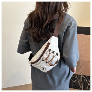 Vue arrière du mannequin portant le sac bandoulière en nylon crème avec détails marrons