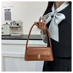 Close-up of retro brown shoulder bag with elegant golden clasp detail and smooth leather finish