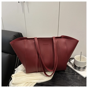 Détail du sac fourre-tout bordeaux avec texte FASHION gaufré et finition mate