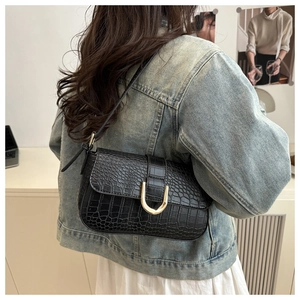 Close-up of black crocodile-embossed PU leather bag with large gold U-shaped metal buckle