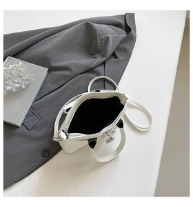 Draufsicht auf minimalistische weiße Ledertasche mit geräumigem Innenraum und schwarzem Futter
