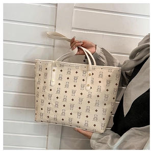 Detail view of cream tote bag featuring cute cartoon bear prints and diamond patterns