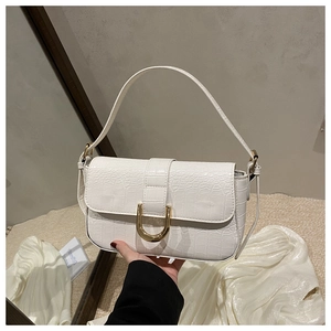 Detail of white crocodile embossed leather bag with premium gold horseshoe buckle