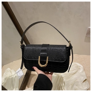 Close-up of black crocodile pattern faux leather with a golden U-shaped metal buckle