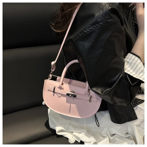 Détail du sac à main rose semi-circulaire avec fermoir argenté et bandoulière réglable