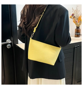 Vue détaillée du dos d'un sac bandoulière en cuir jaune avec boucles en métal doré