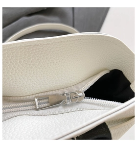 Makro-Detail von hochwertigem silbernem Metallreißverschluss an weißer Lederhandtasche
