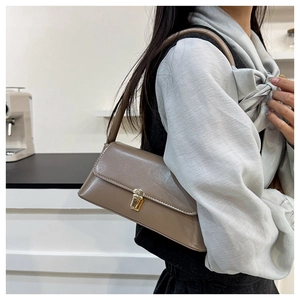 Detail of coffee brown shoulder bag featuring a vintage golden square metal twist lock