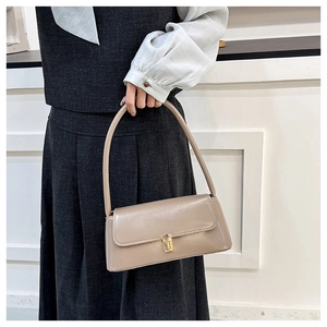 Detailed close-up of glossy khaki shoulder bag featuring a refined golden metal clasp