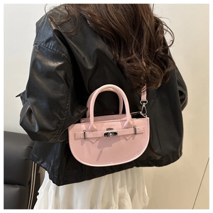 Détail du sac selle rose semi-circulaire avec fermoir rotatif argenté sur cuir noir