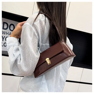 Detailed side view of a vintage dark red baguette shoulder bag with golden metal buckle