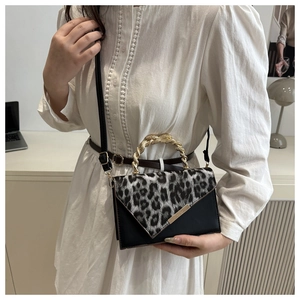 Detail of leopard print contrast shoulder bag with golden twisted handle and leather strap