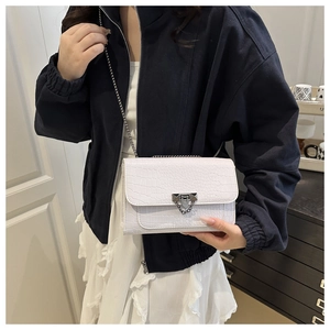Close-up of white crocodile pattern PU leather crossbody bag with silver chain strap