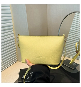 Détail du sac bandoulière en cuir jaune à grain de litchi et finitions dorées