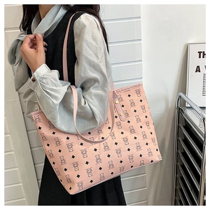 Detail of pink tote bag with bear patterns, PU leather texture, and reinforced straps