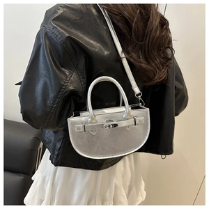Détail du sac demi-lune argenté avec fermoir rotatif en métal et texture cuir lisse