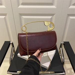 Borsa bordeaux in pelle PU con esclusivo manico in metallo a forma di spilla dorata