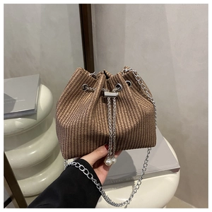 Détail du sac seau tressé avec cordon à perles et bandoulière chaîne