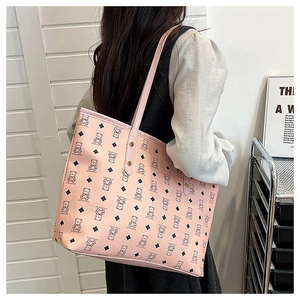 Detail of pink leather tote bag with bear print pattern shown on model shoulder