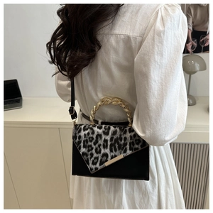 Detail of leopard print flap and gold braided handle on trendy leather shoulder bag