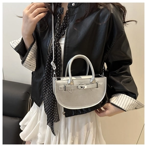 Sac croissant argenté moderne porté par un mannequin dans une tenue urbaine tendance