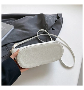 Détail de la base ovale et des coutures du sac seau blanc à motif litchi