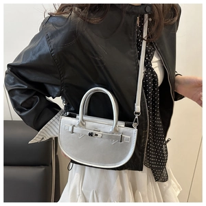 Détail du sac à main demi-lune argenté avec poignée supérieure et fermoir rotatif