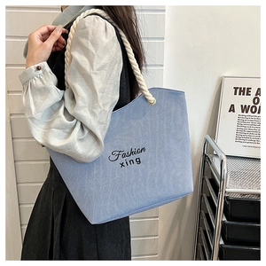Blue and white striped canvas tote bag with thick rope handles and fashion text detail