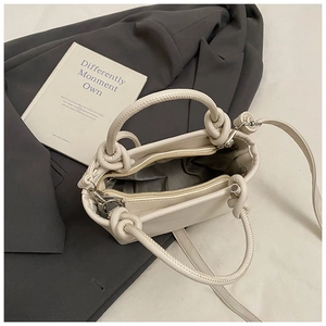 Close-up of cream bucket bag interior with zipper closure and lychee grain leather