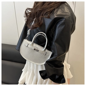 Sac à bandoulière argenté en forme de demi-lune avec fermoir métallique sur un mannequin