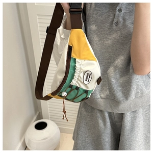 Détail du sac de poitrine en toile multicolore avec bandoulière réglable et boucle