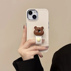 Close-up of creamy silicone iPhone case featuring a cute 3D brown bear ring holder stand