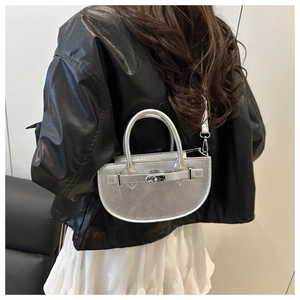 Détail du sac demi-lune argenté avec finition métallisée et fermoir tournant argenté