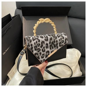 Detail of leopard print flap bag with unique gold snake handle in premium gift packaging