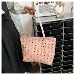 Detailed close-up of pink tote bag with bear print and sturdy metal rivet accents