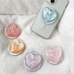 Pearlescent heart-shaped phone grip with silver bow accent and foldable base