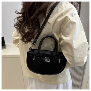 Détail du sac demi-lune en cuir noir avec boucle en métal argenté et bandoulière réglable