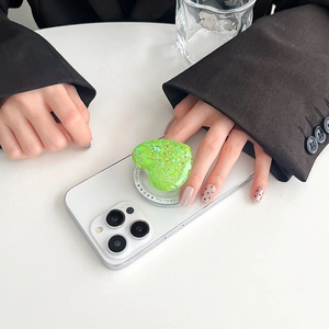Detail of glitter green heart Magsafe phone grip showing the Gift For You base text
