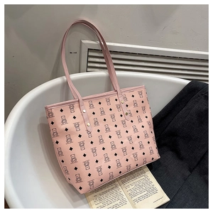 Detailed close-up of pink tote bag with bear pattern and golden rivet strap attachment