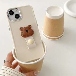 Detail of cream silicone iPhone case with a cute brown 3D bear wrist strap stand