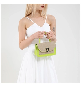 Dettaglio borsa verde neon con patta intrecciata e fibbia metallica a forma di D