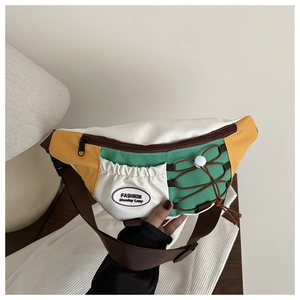Detailed shot of tri-color crossbody bag featuring yellow and green panels with elastic cord