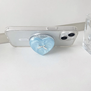 Detail of light blue heart phone grip with pearl texture and silver bow on clear case