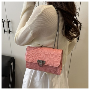 Pink croc-embossed small square bag with metallic chain strap shown from a side view