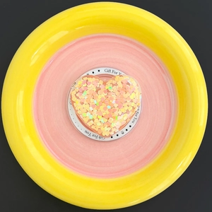 Detail of glittery heart-shaped phone grip with magnetic sequins on a ceramic base