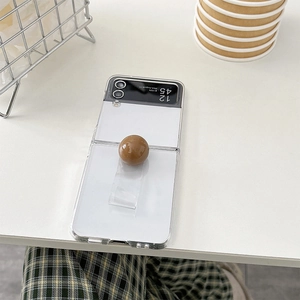 Detail of transparent Z Flip case with a glossy brown decorative ball ring grip