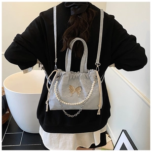 Detail of light blue butterfly backpack with pearl chain and elegant drawstring closure