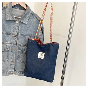 Détail du cabas en jean avec bandoulière en corde colorée et doublure à carreaux